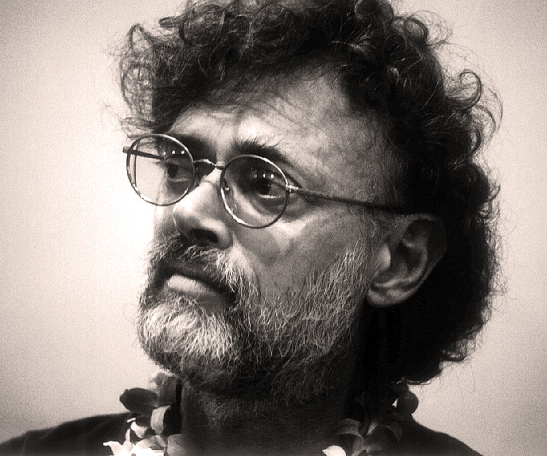 Terence McKenna with round glasses and a beard, photographed by Jon Hanna in 1999.